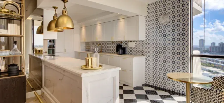 A kitchen with a checkered floor , a large island , and a table.