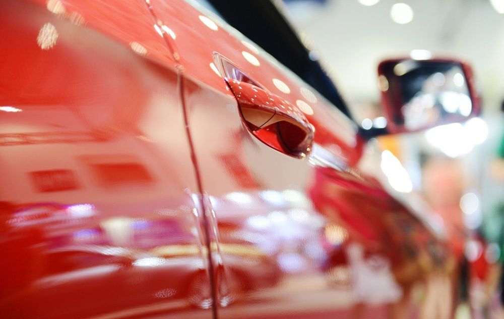 Primo piano di un'auto sportiva rosso lucido con pois bianchi in mostra