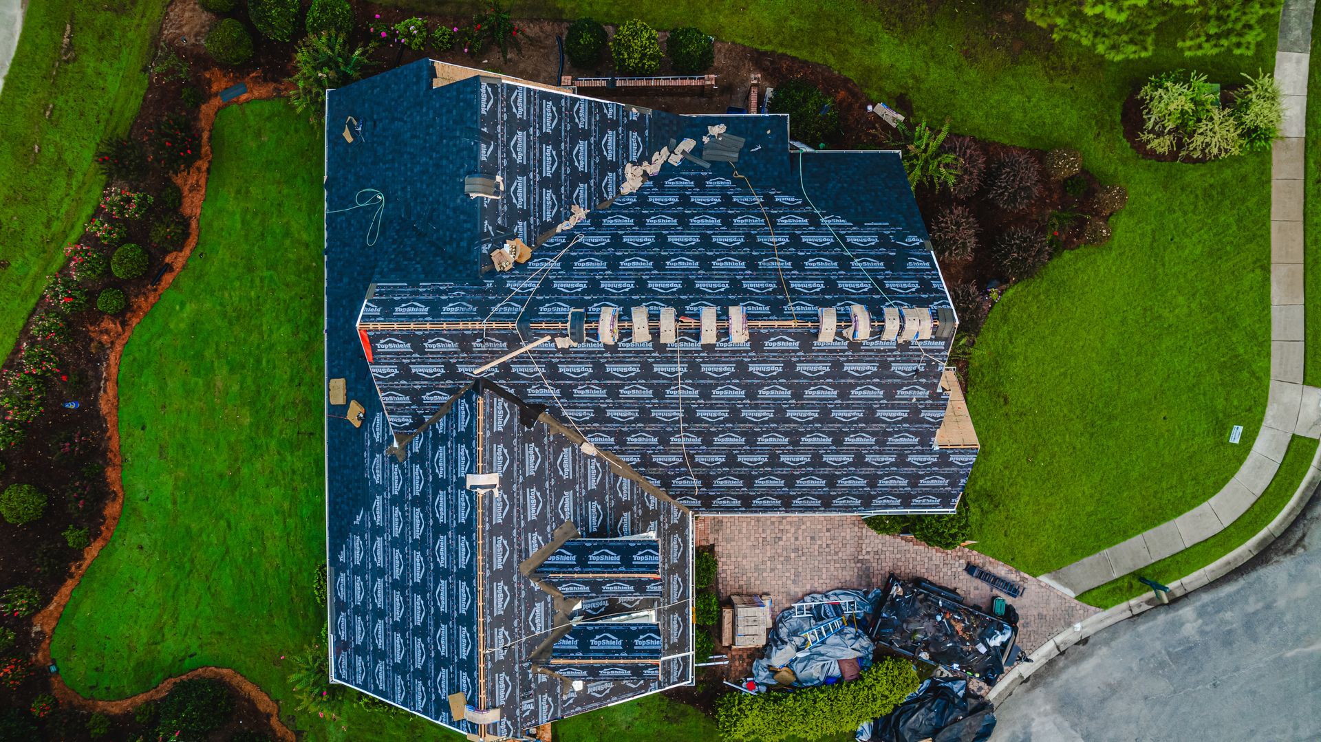 An aerial view of a house with a roof that is being installed.