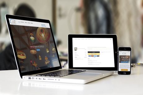 A laptop , tablet , and cell phone are sitting on a table.