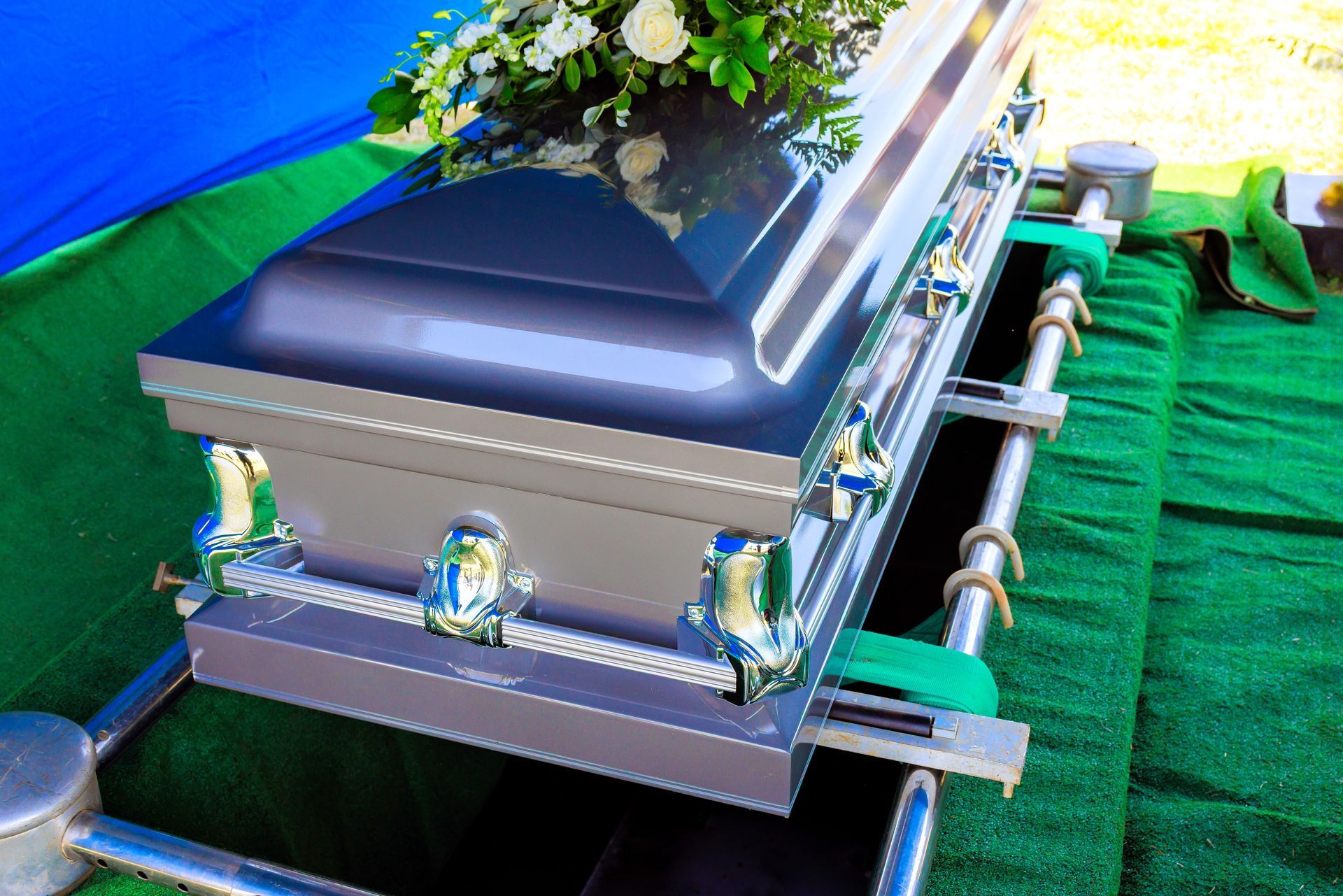 A man in a suit is sitting at a coffin at a funeral.