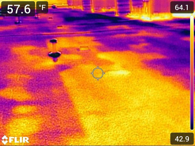 Thermal image showing a surface with varying temperatures, represented by yellow and purple hues. The temperature scale ranges from 42.9°F to 64.1°F.