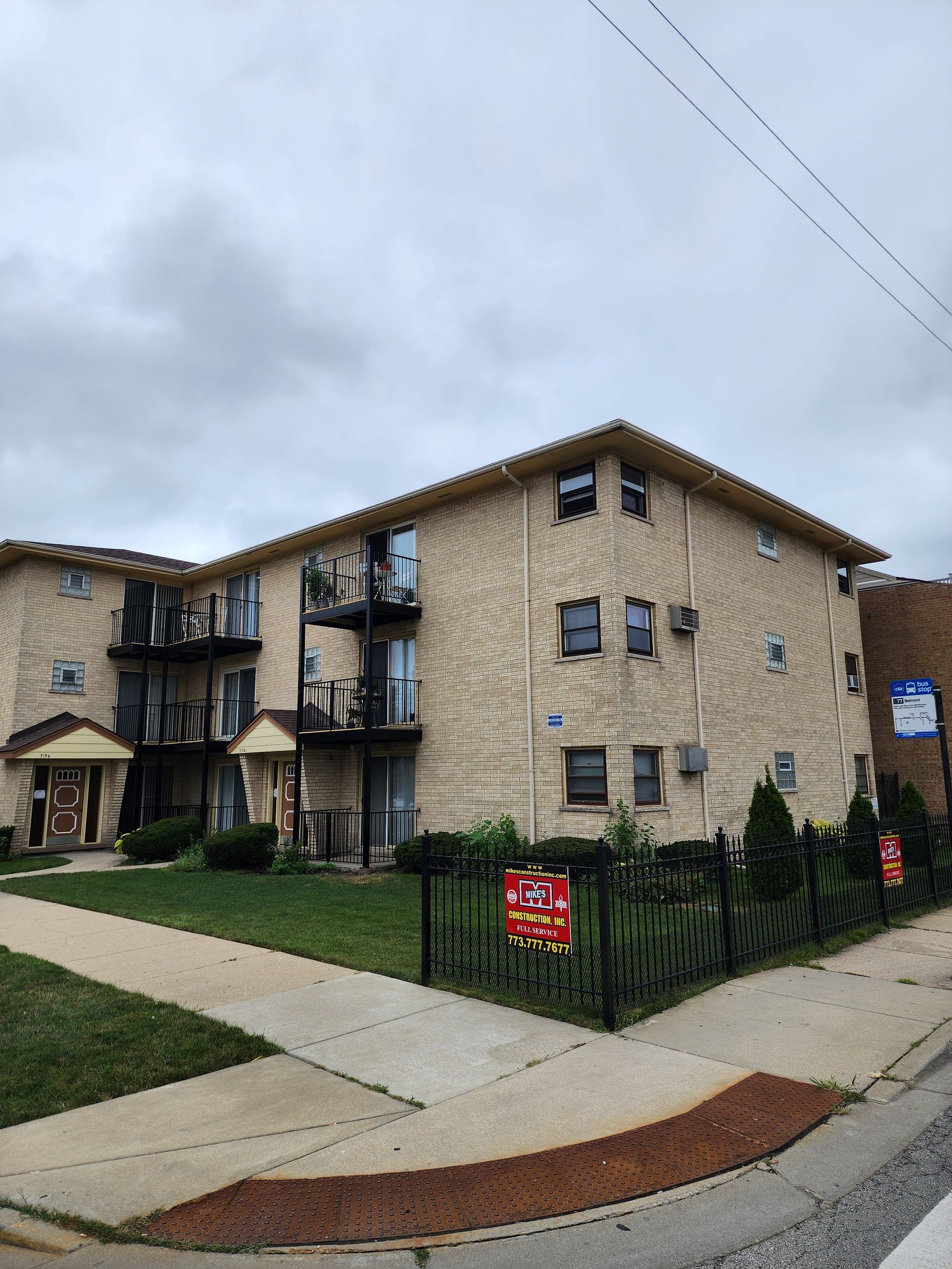 A large apartment building with a lot of windows is for sale.