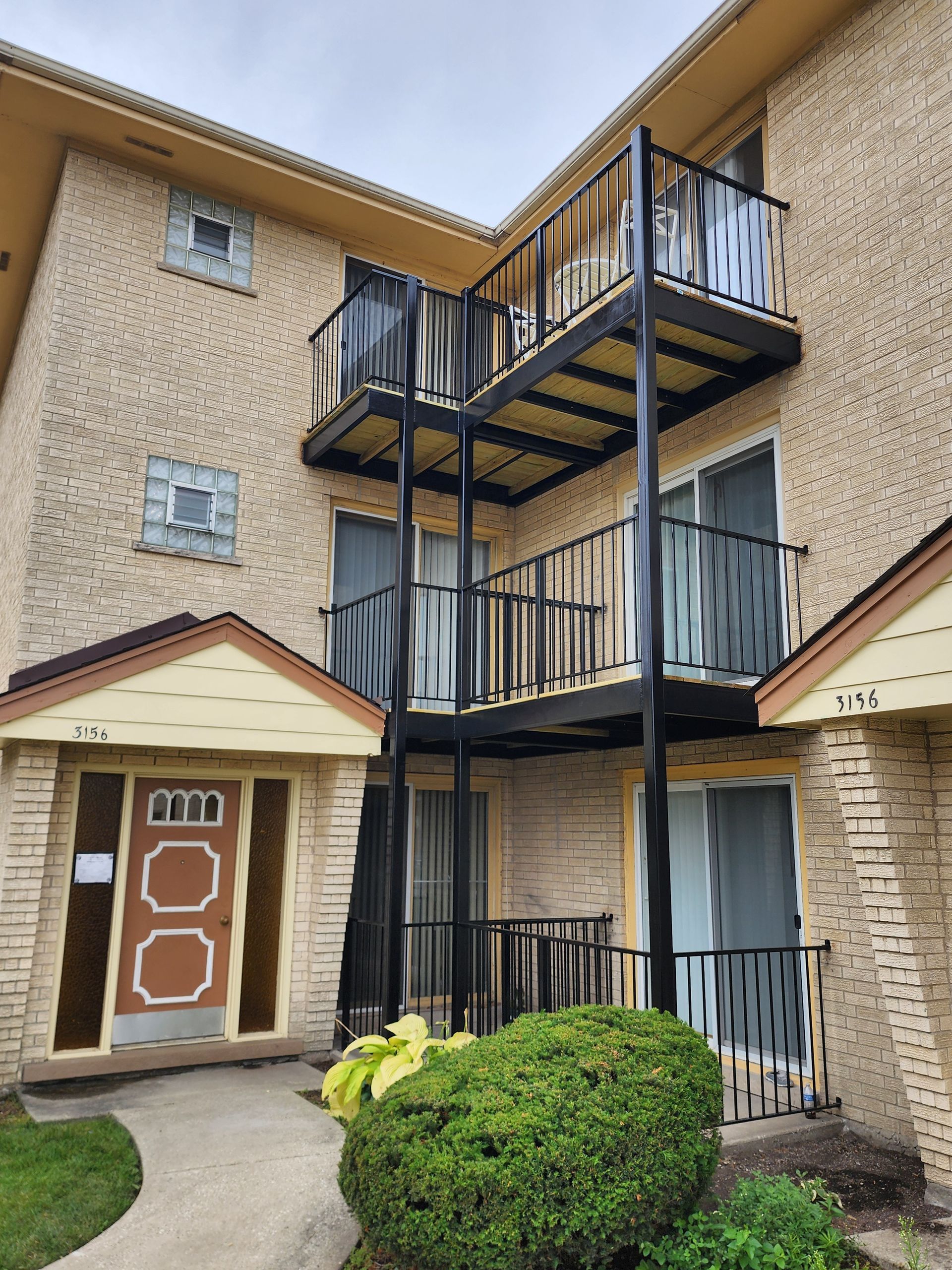 A brick apartment building with balconies and stairs