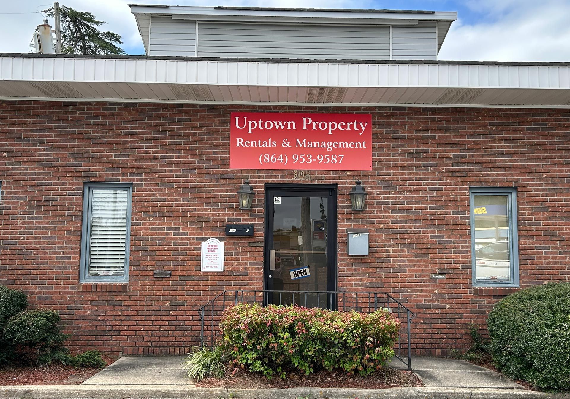 Brick building with a sign for Uptown Property Rentals & Management