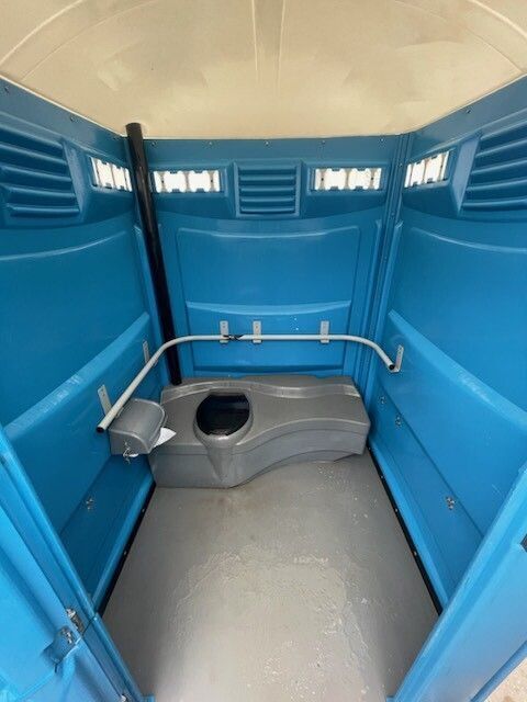 A blue portable toilet with a toilet in it
