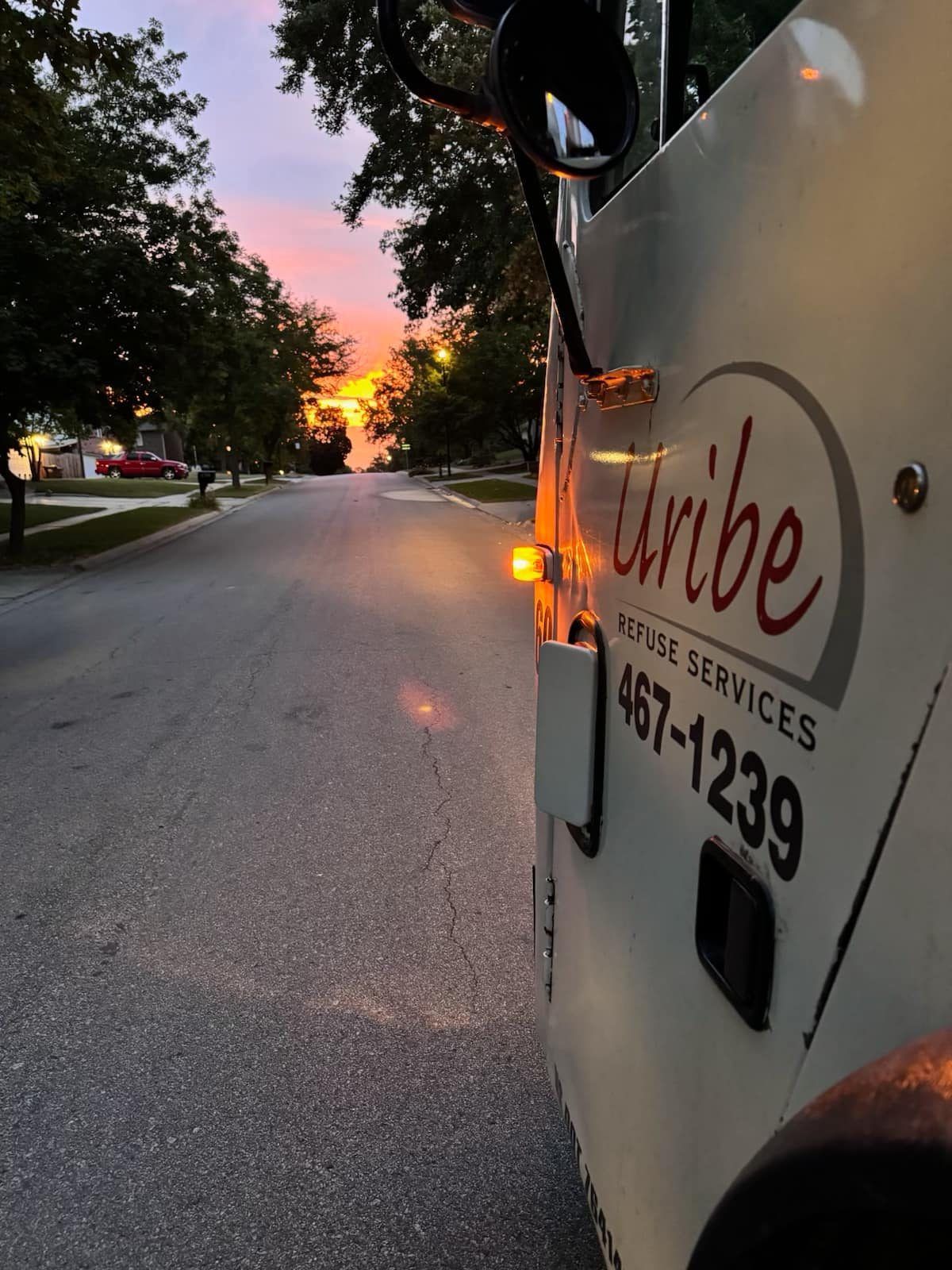 A white uribe truck is parked on the side of the road