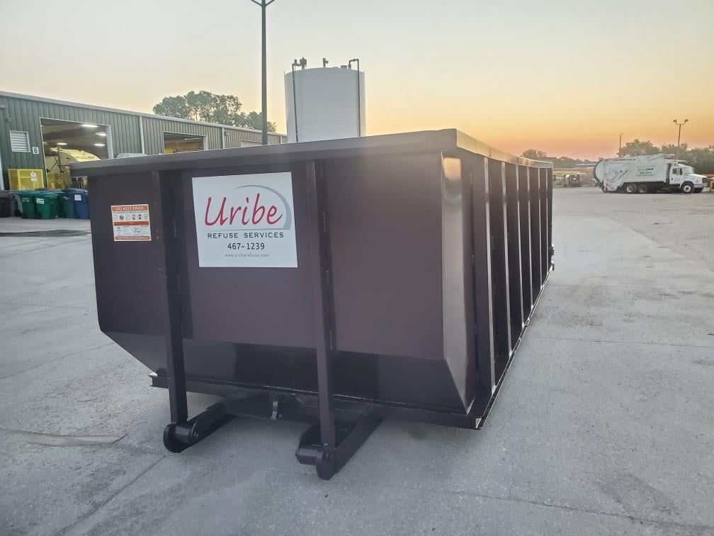 A row of red portable toilets are lined up in a parking lot.
