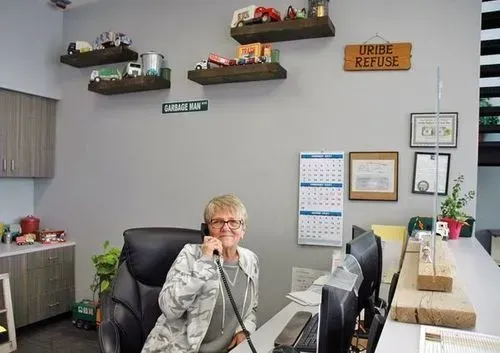 A woman is sitting at a desk talking on a phone.