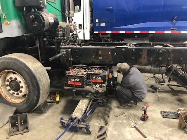 A man is working on a truck in a garage.