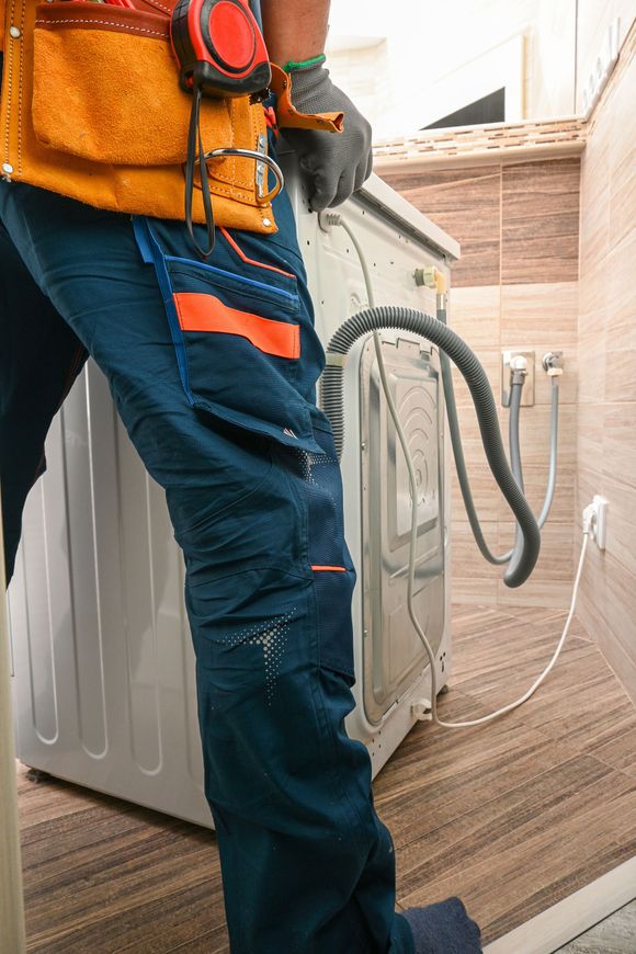 Man in a safety vest measures a hallway with a device.