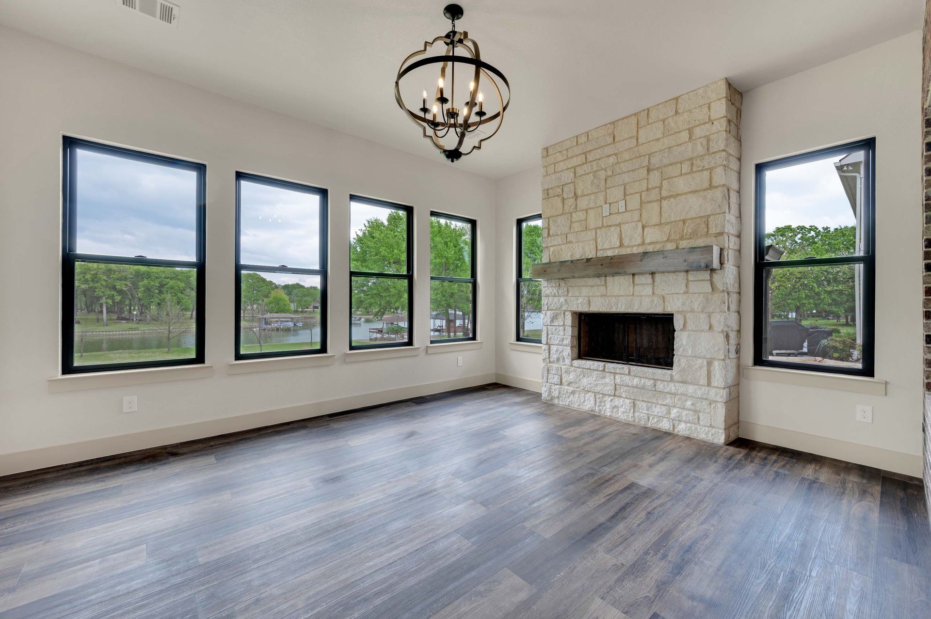 living room with stone fireplace and large windows