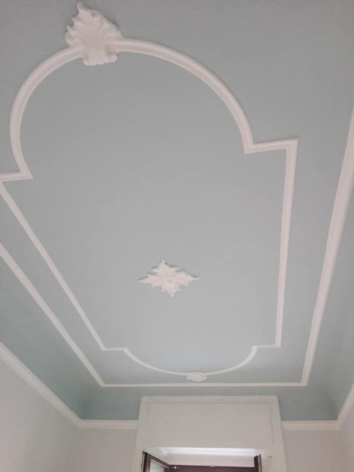 Soffitto blu con modanature decorative bianche: un grande pannello centrale e rifiniture.