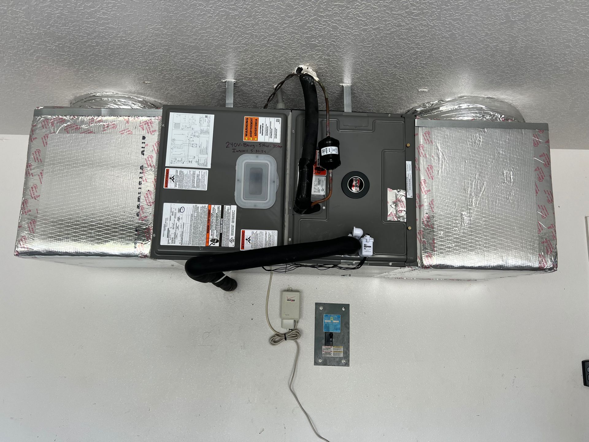 HVAC unit attached to the ceiling, with insulated ductwork. Electrical box and thermostat below.