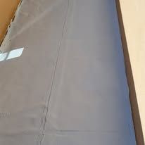 Gray tarp covering a surface, with a vertical seam.