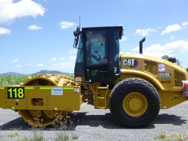 A yellow cat tractor is parked on the side of the road