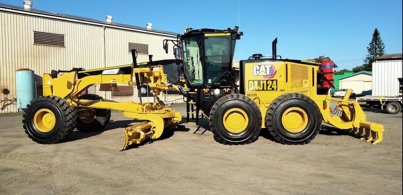 A yellow excavator is moving dirt and rocks on a construction site.