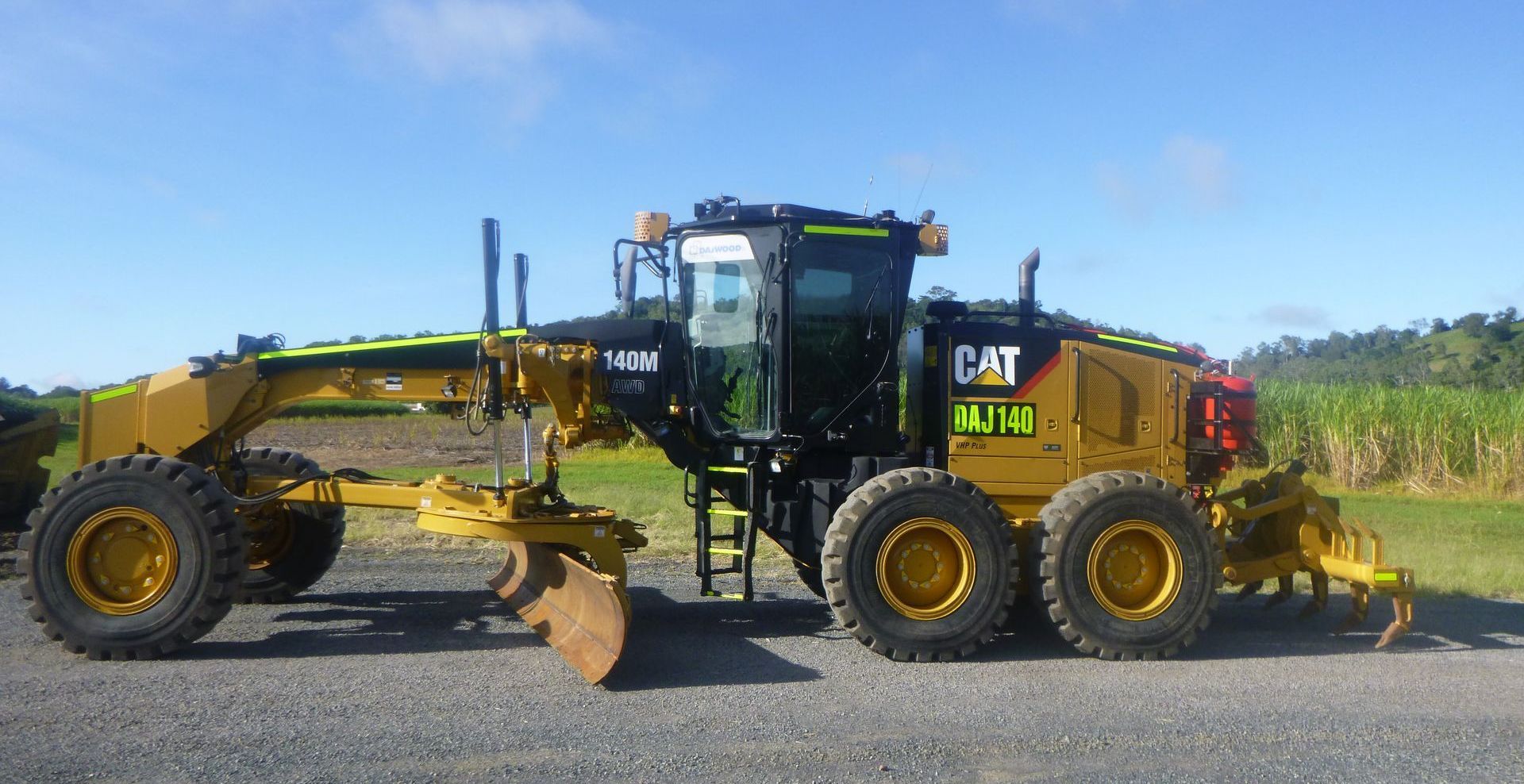 An orange excavator is digging a pile of dirt in a field.