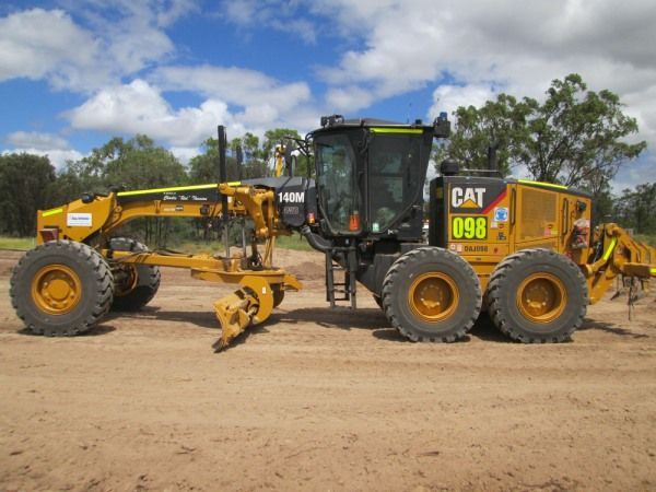A cat 098 tractor is parked in a dirt field