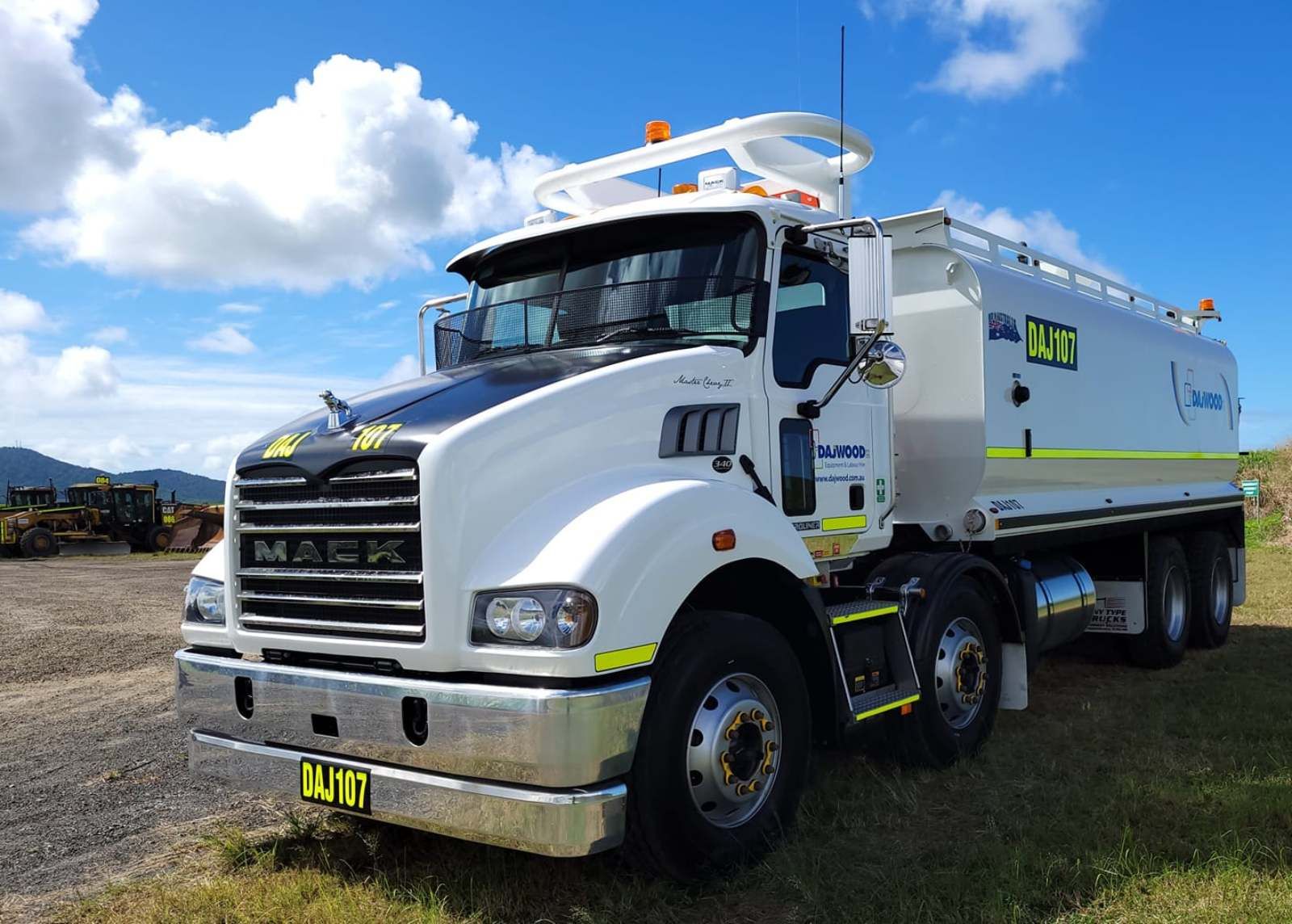 A large white truck is parked in a grassy field.