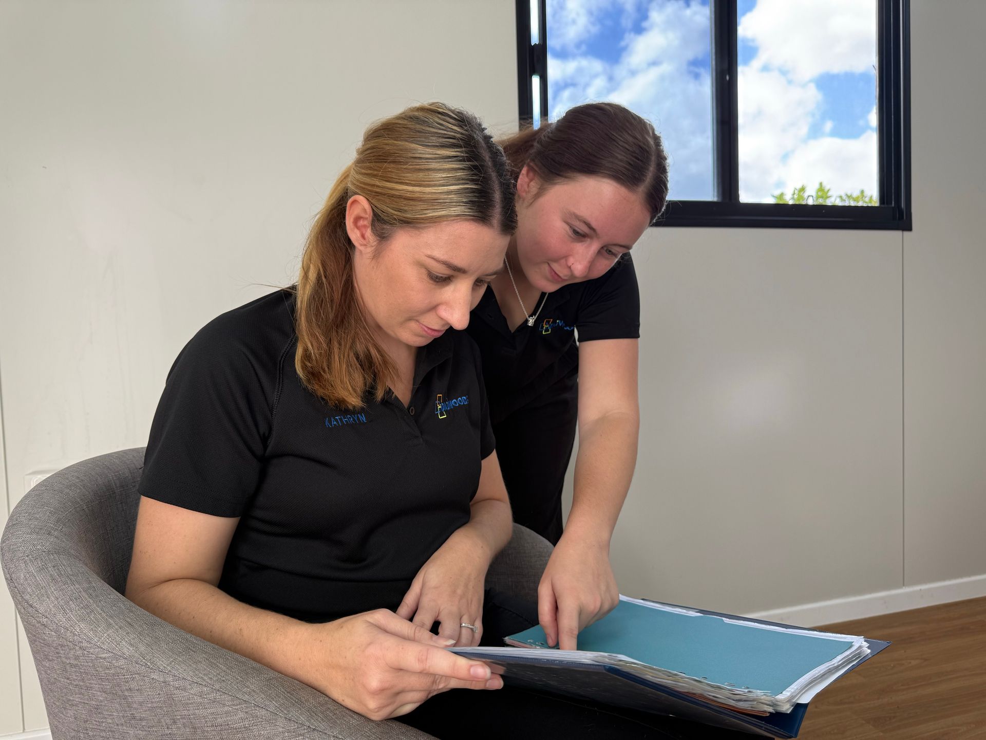 Two construction workers are sitting on a bulldozer at a construction site.