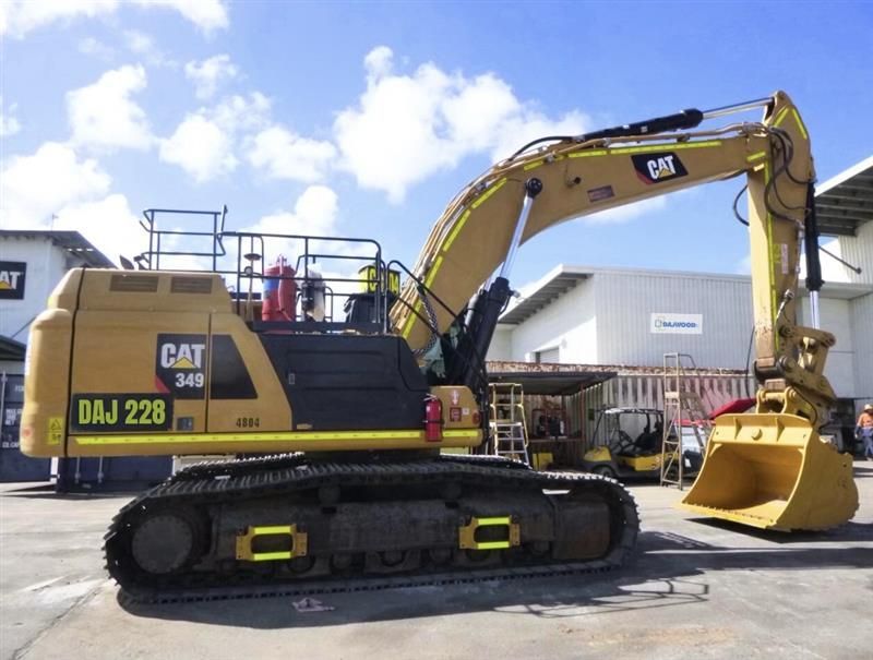 A large yellow excavator is sitting on top of a flatbed truck.