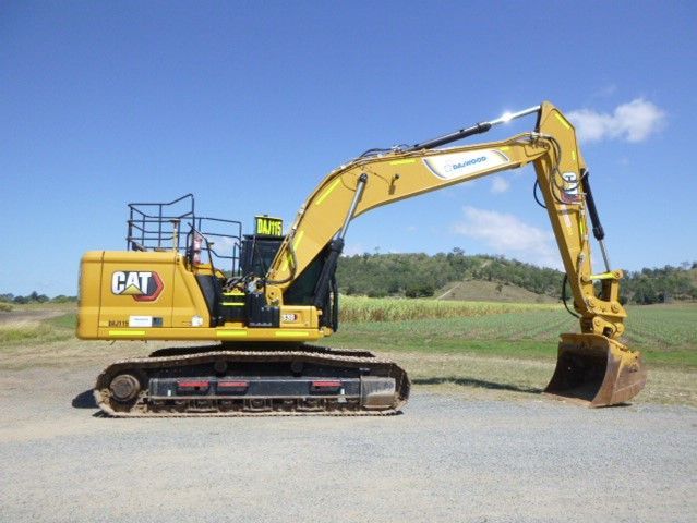 A yellow cat excavator is parked on the side of the road