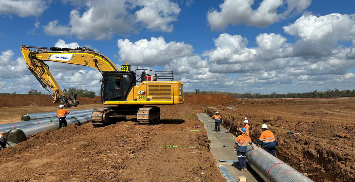 A yellow bulldozer is parked in a dirt field.