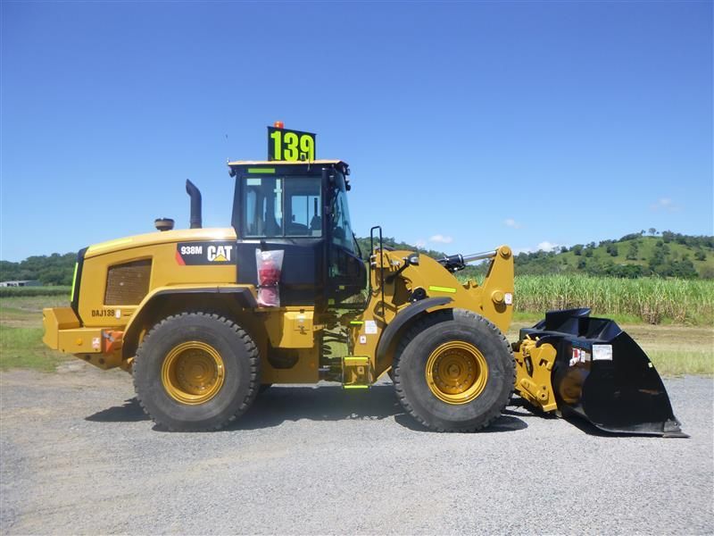 A white truck with a yellow railing is parked in a dirt field.
