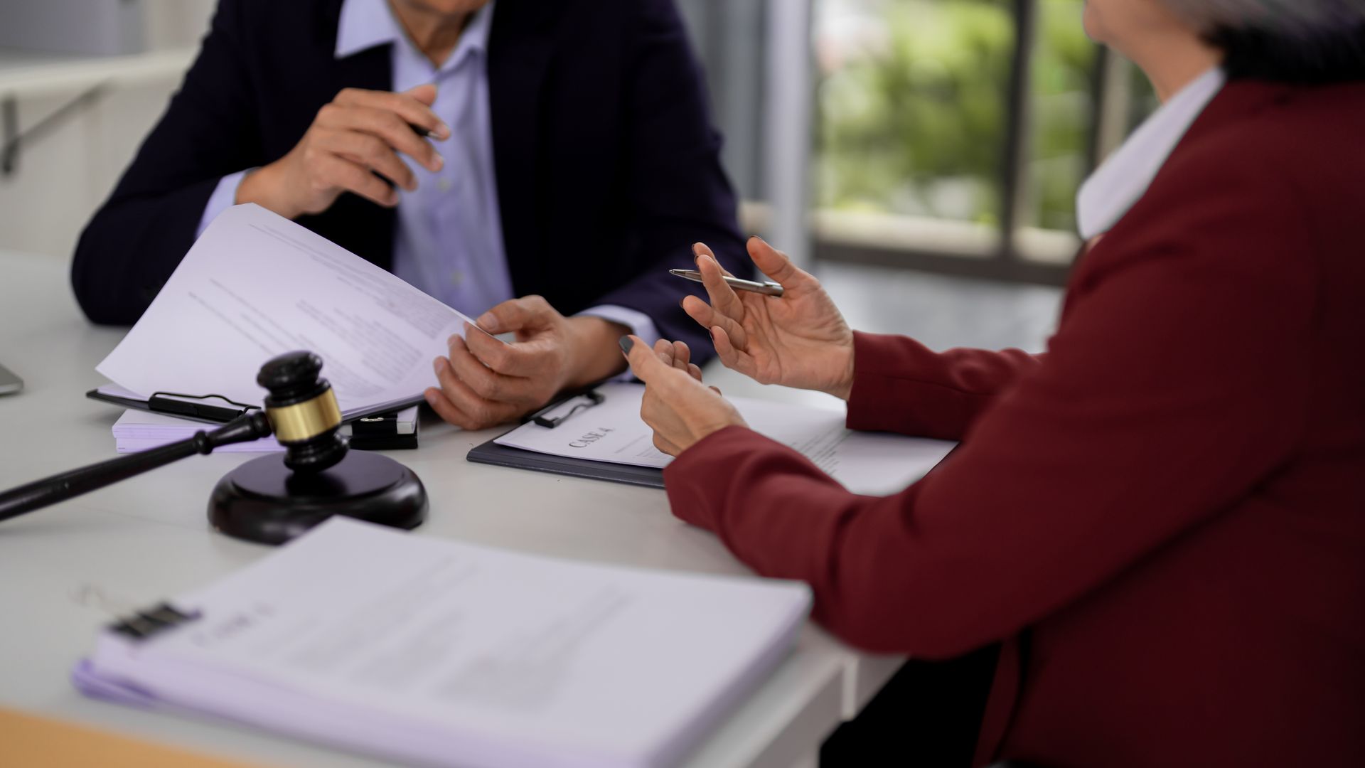 A trusts attorney reviewing legal documents during a private client consultation in an office.