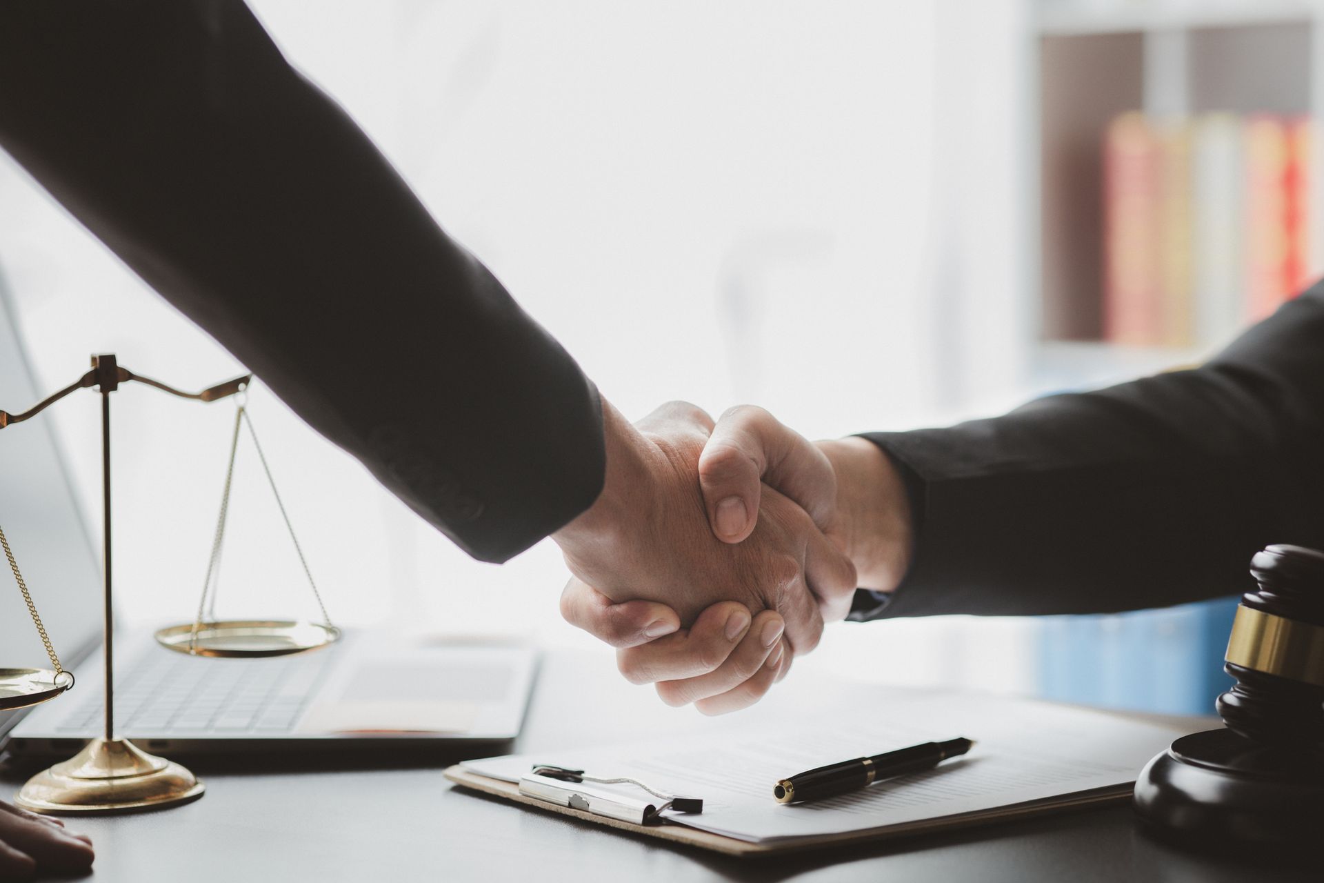 Trusts lawyers shaking hands after signing estate planning documents.