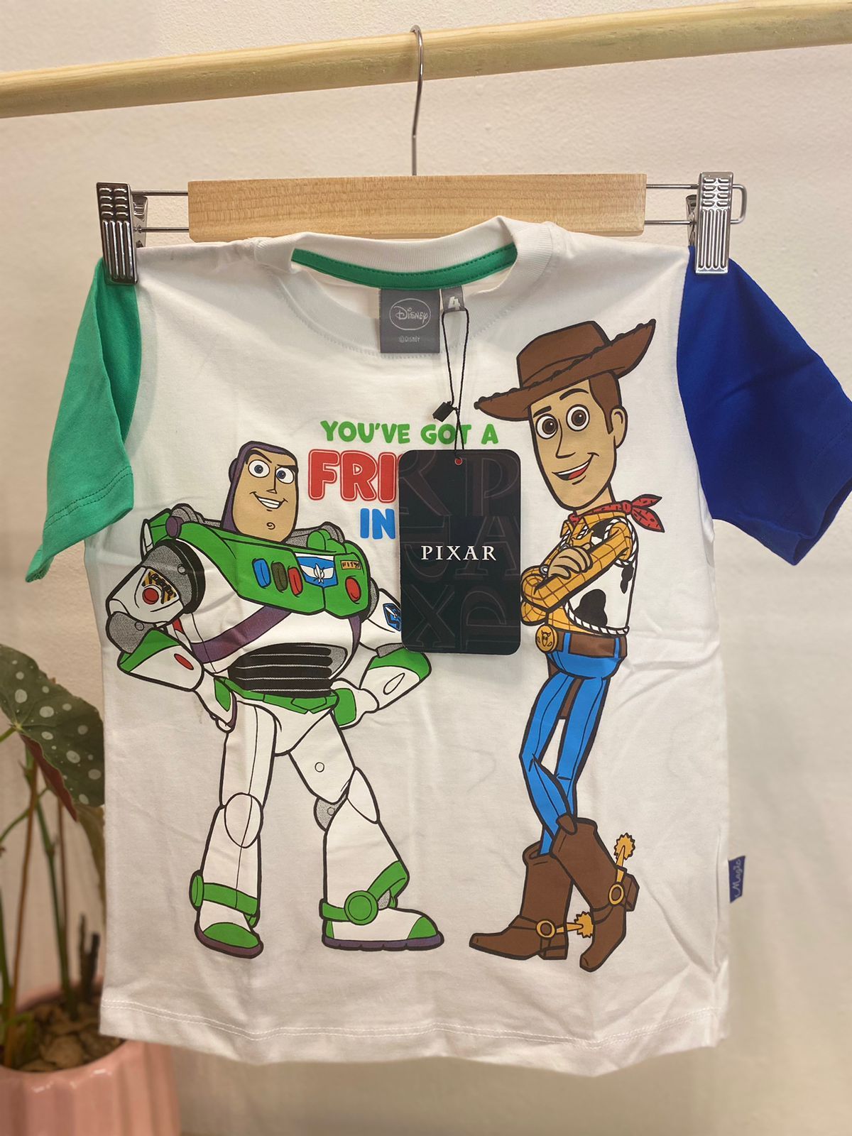 Camiseta de Toy Story con Buzz Lightyear y Woody, camisa blanca, mangas verdes y azules, texto "Tienes un amigo en mí".