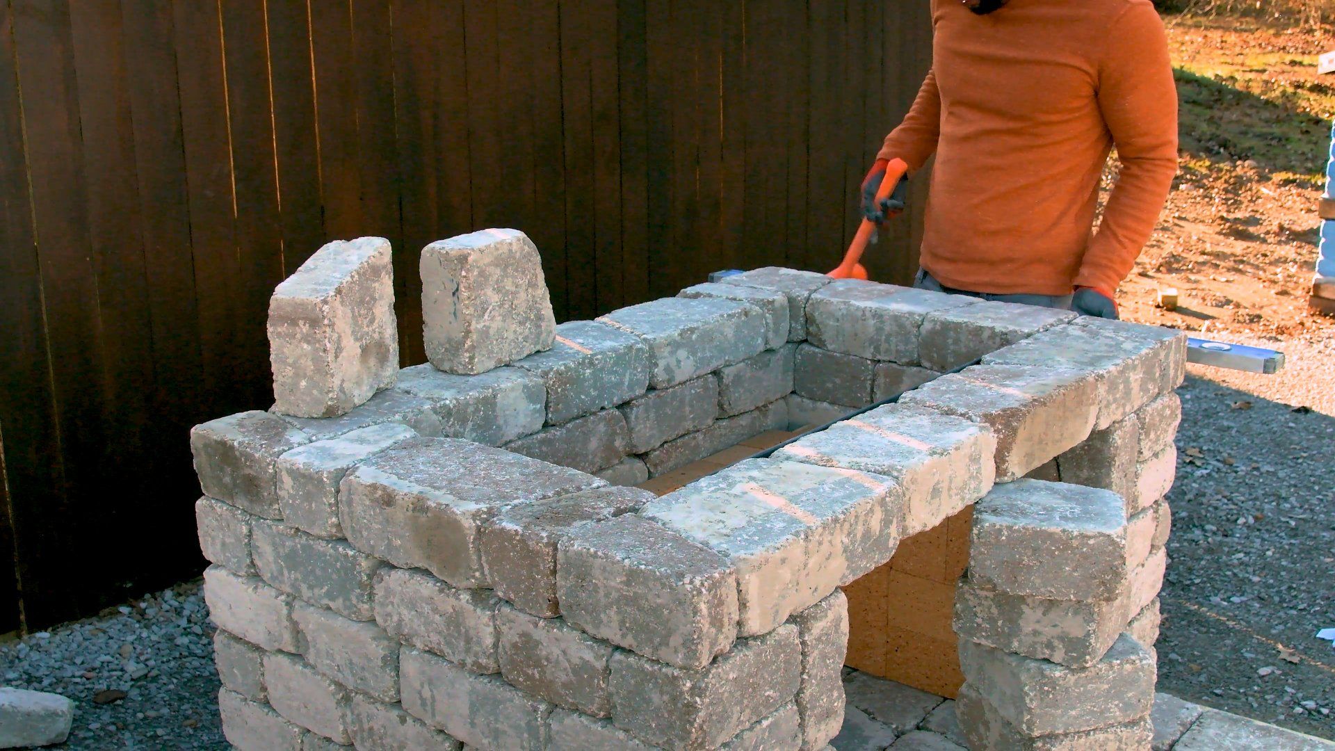 The fiirst course of block are laid along the angle. Note the temporary stack of blocks to support the course from tipping and falling out.