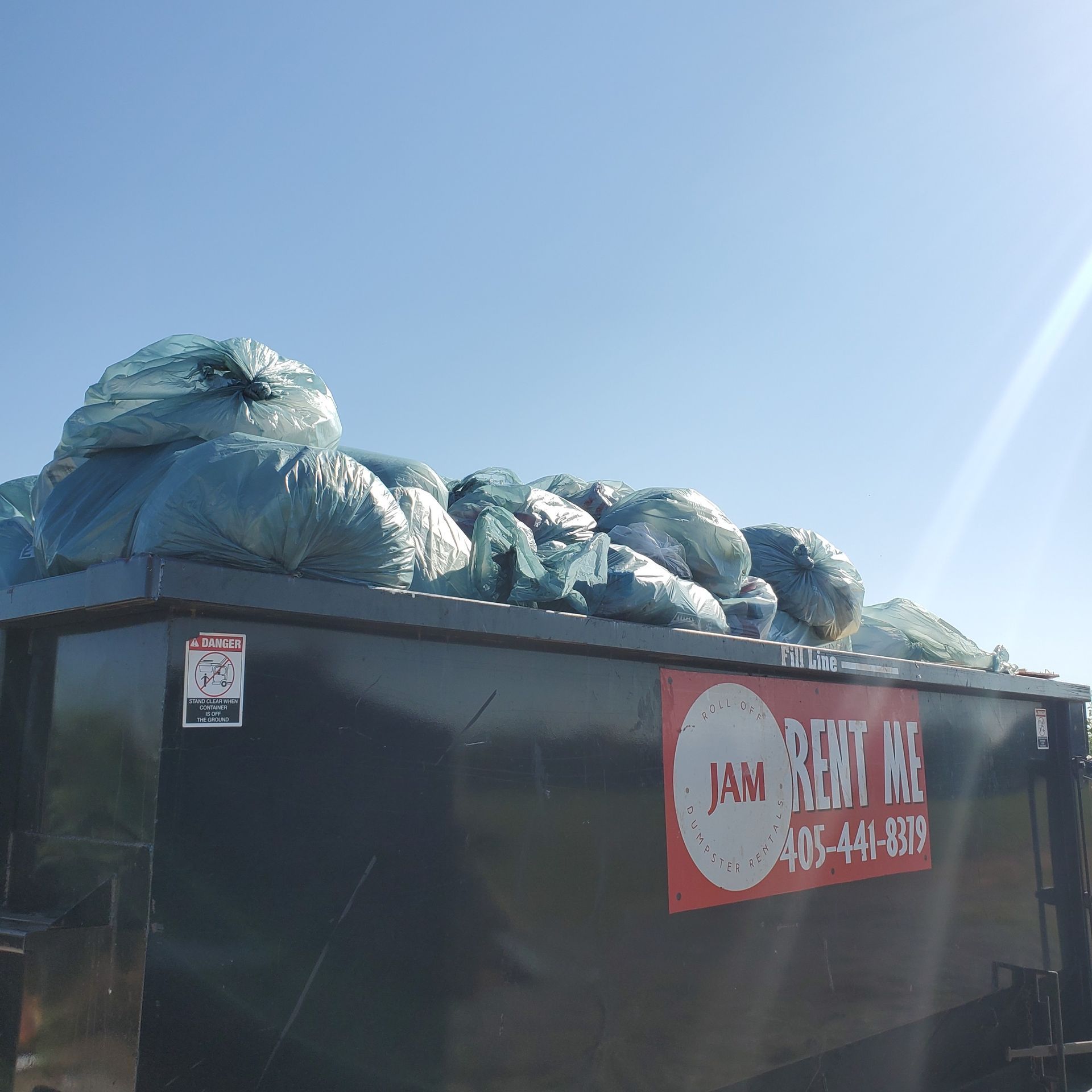 a dumpster that over filled with trash bags