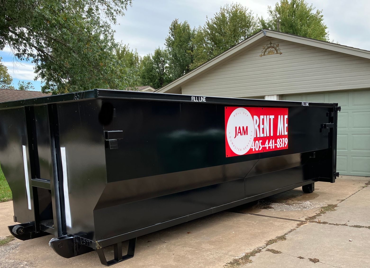A dumpster is parked in front of a house.