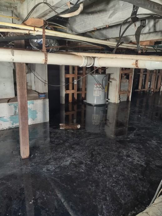 Basement flooded with water. Visible water heater and wooden support structures.