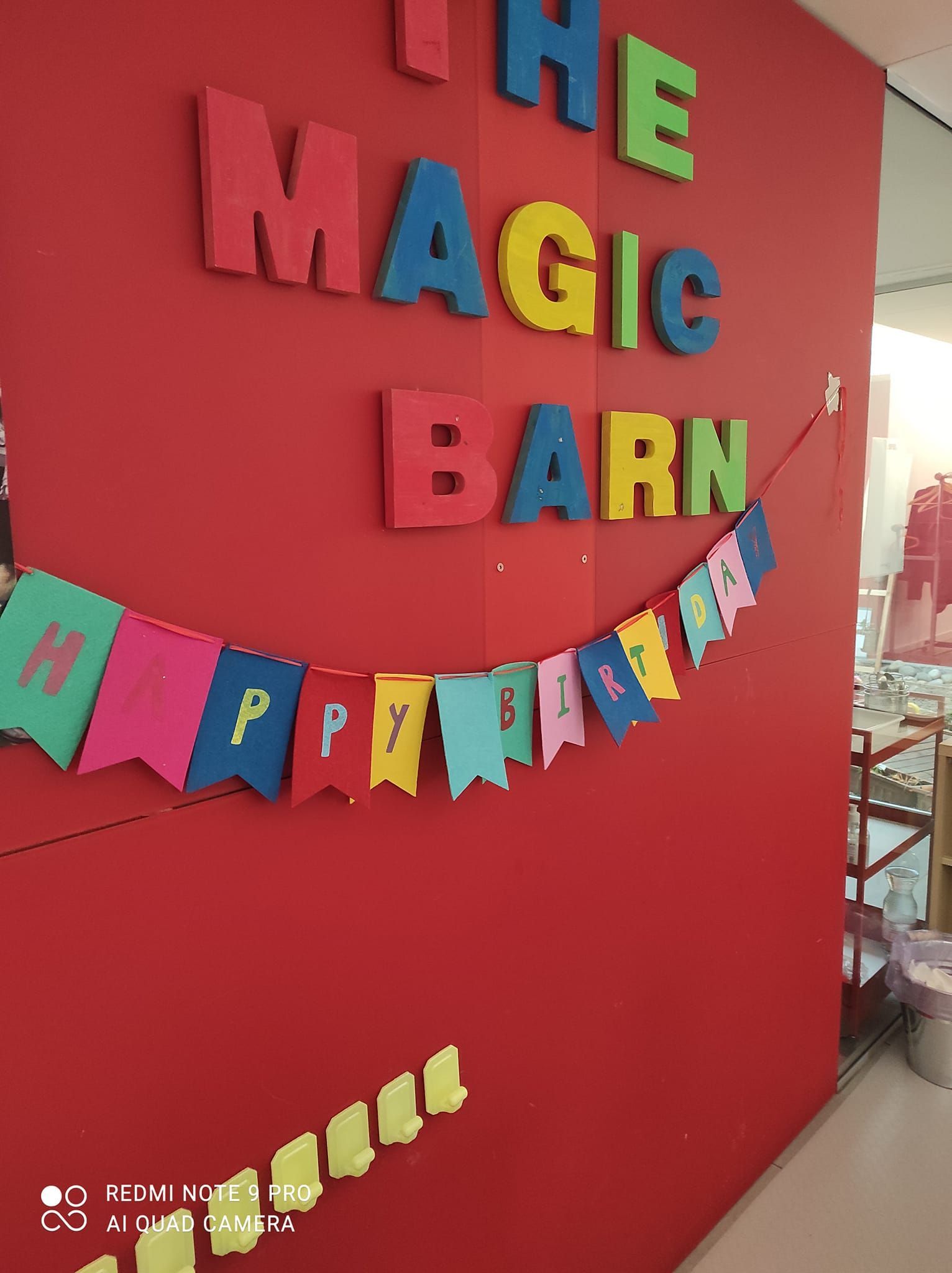 Un muro rosso con la scritta il fienile magico sopra