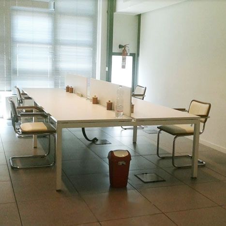 Una stanza con tavoli e sedie e un cestino della spazzatura