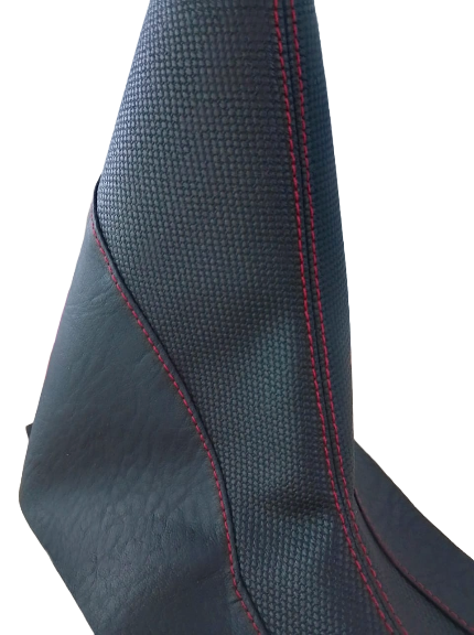 Bota de cambio negra con costuras rojas, en ángulo, sobre fondo blanco.