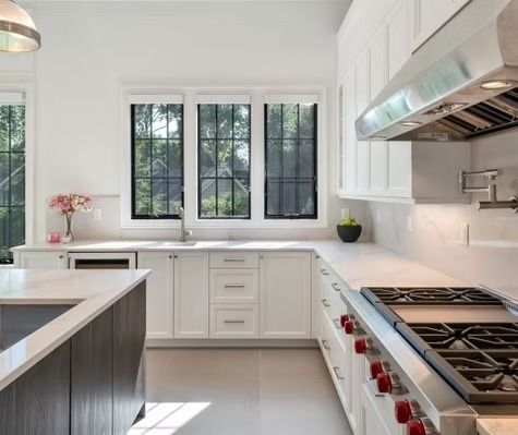 A kitchen with white cabinets and stainless steel appliances
