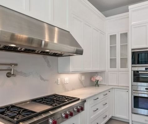 A kitchen with stainless steel appliances and white cabinets