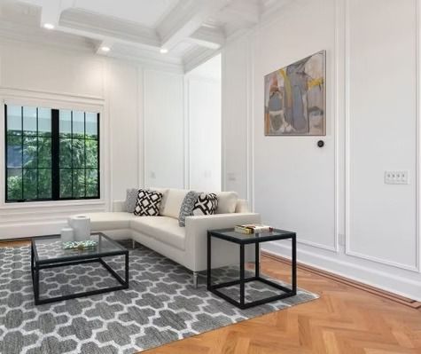 A living room with a couch , two coffee tables , and a rug.