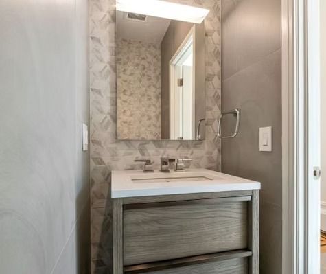 A bathroom with a sink , mirror and towel rack.