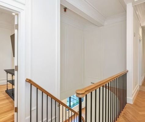 A staircase with a wooden railing and a black railing