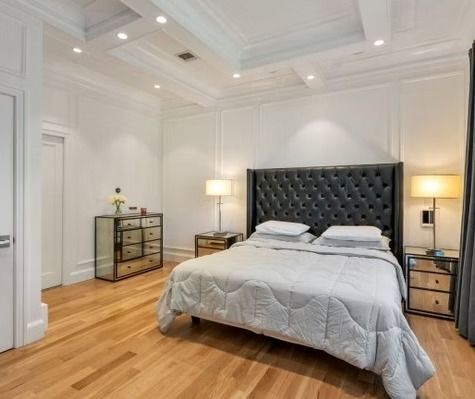 A bedroom with a large bed and a dresser