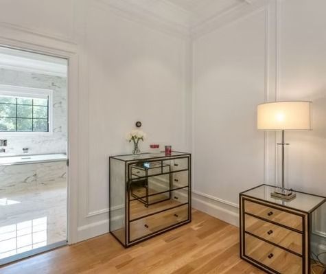 A bedroom with a mirrored dresser and two nightstands.