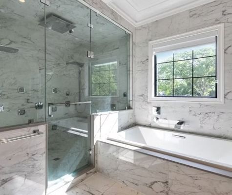 A bathroom with a tub , shower , and window.
