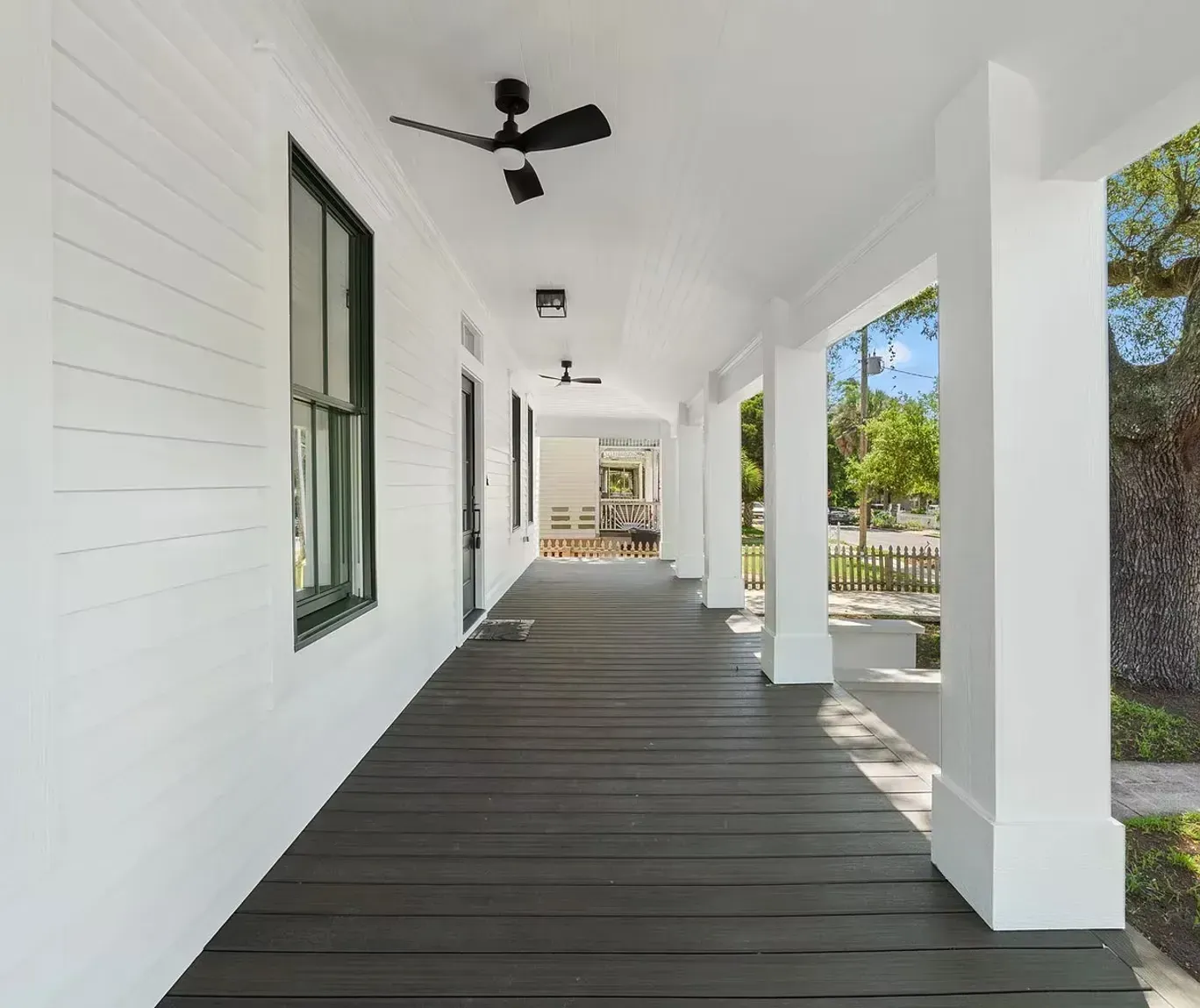 A long porch with a ceiling fan on it