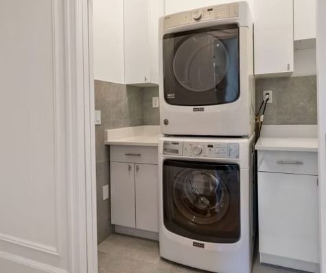 A washer and dryer are stacked on top of each other in a laundry room.