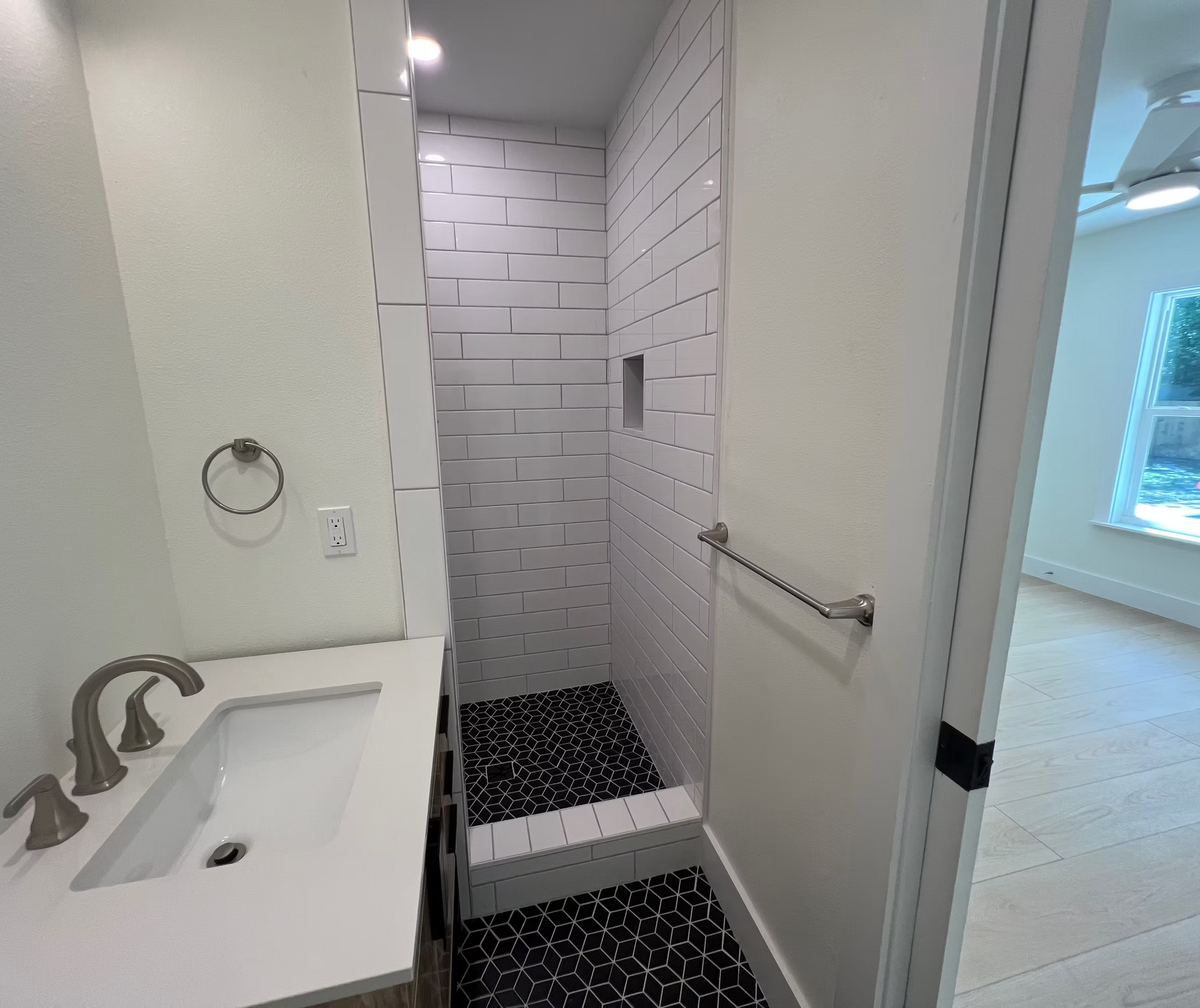 A bathroom with a sink and a walk in shower.